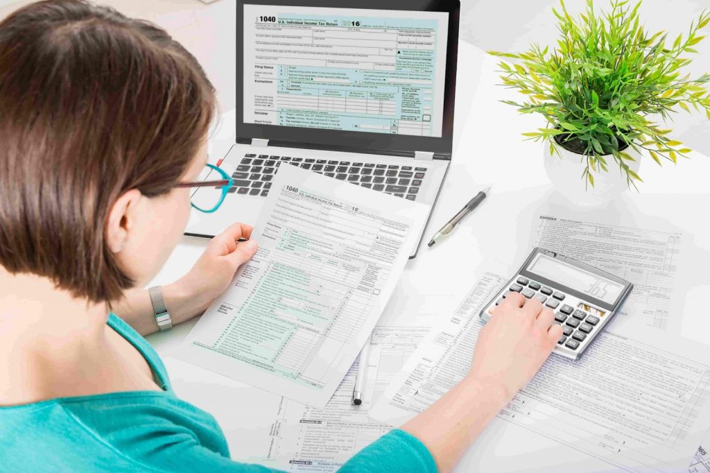 Woman doing tax returns computation on calculator