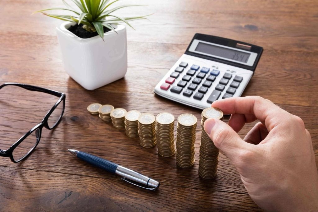 man calculating tax and stacking coins