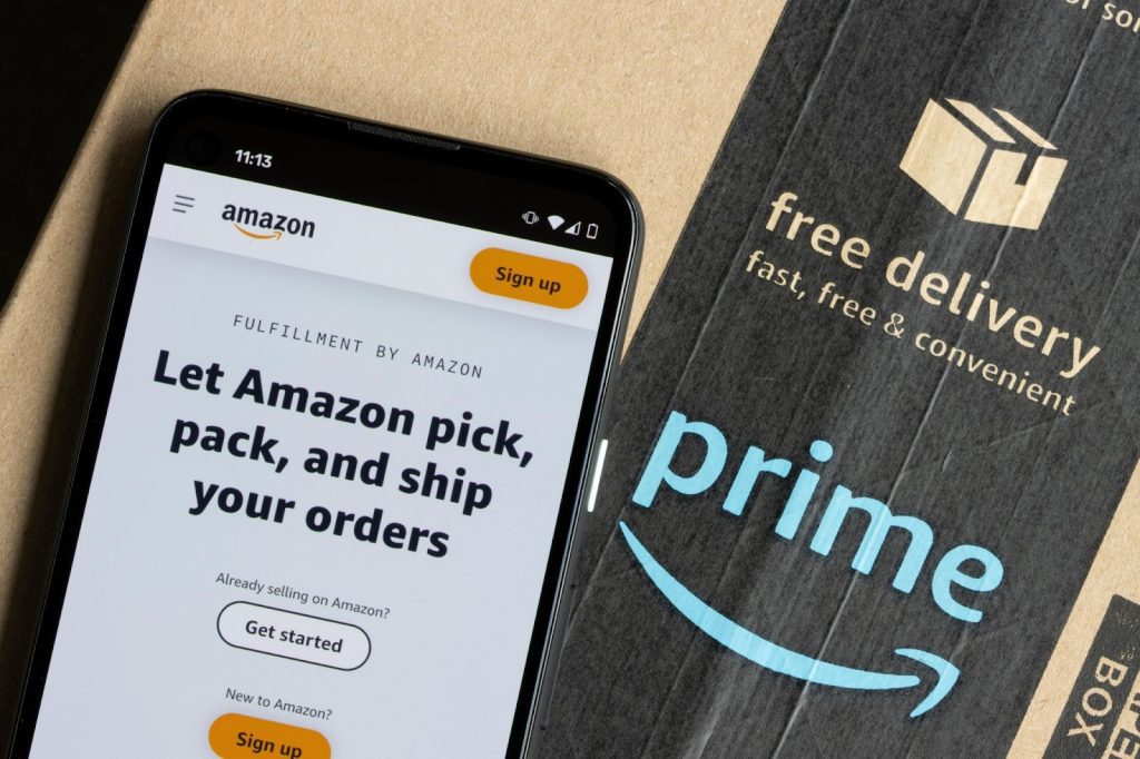 A mobile phone, showing Amazon FBA, on top of an Amazon prime package