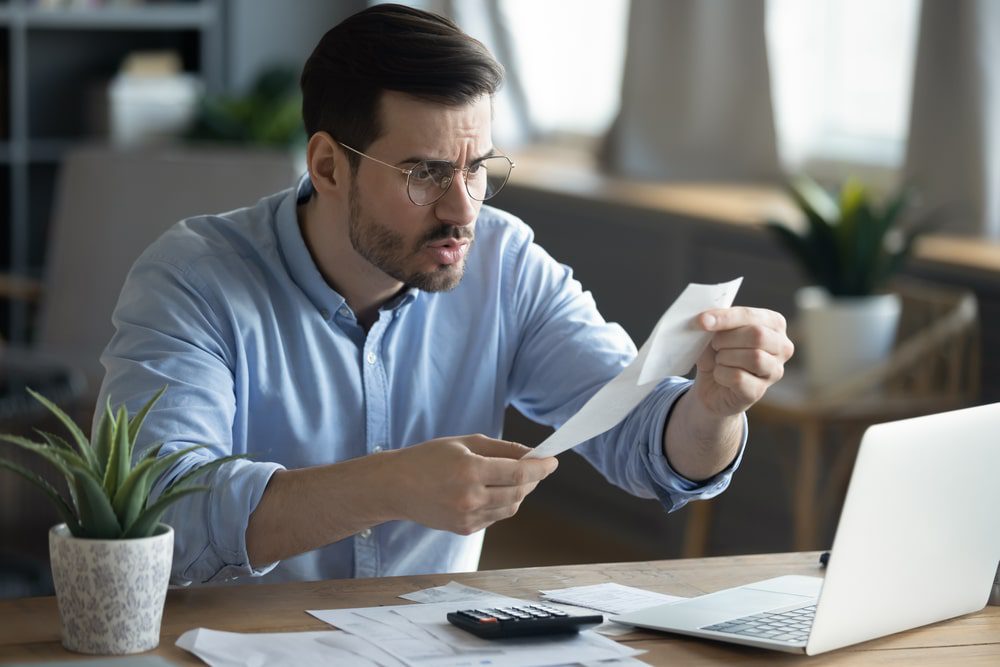 outsourced bookkeeping - a man frustrated with a financial bill