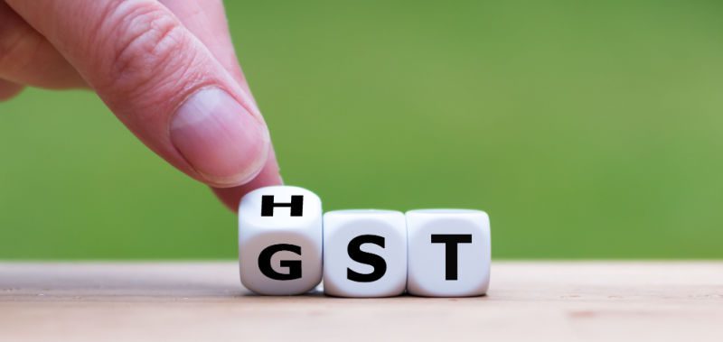 Dice revealing and interchangeable HST and GST, symbolizing how they have the same functions in Canadian tax policy.