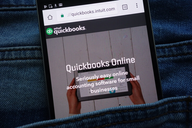 QuickBooks Online home page on the screen of a smartphone loosely tucked in a jean’s back pocket. 